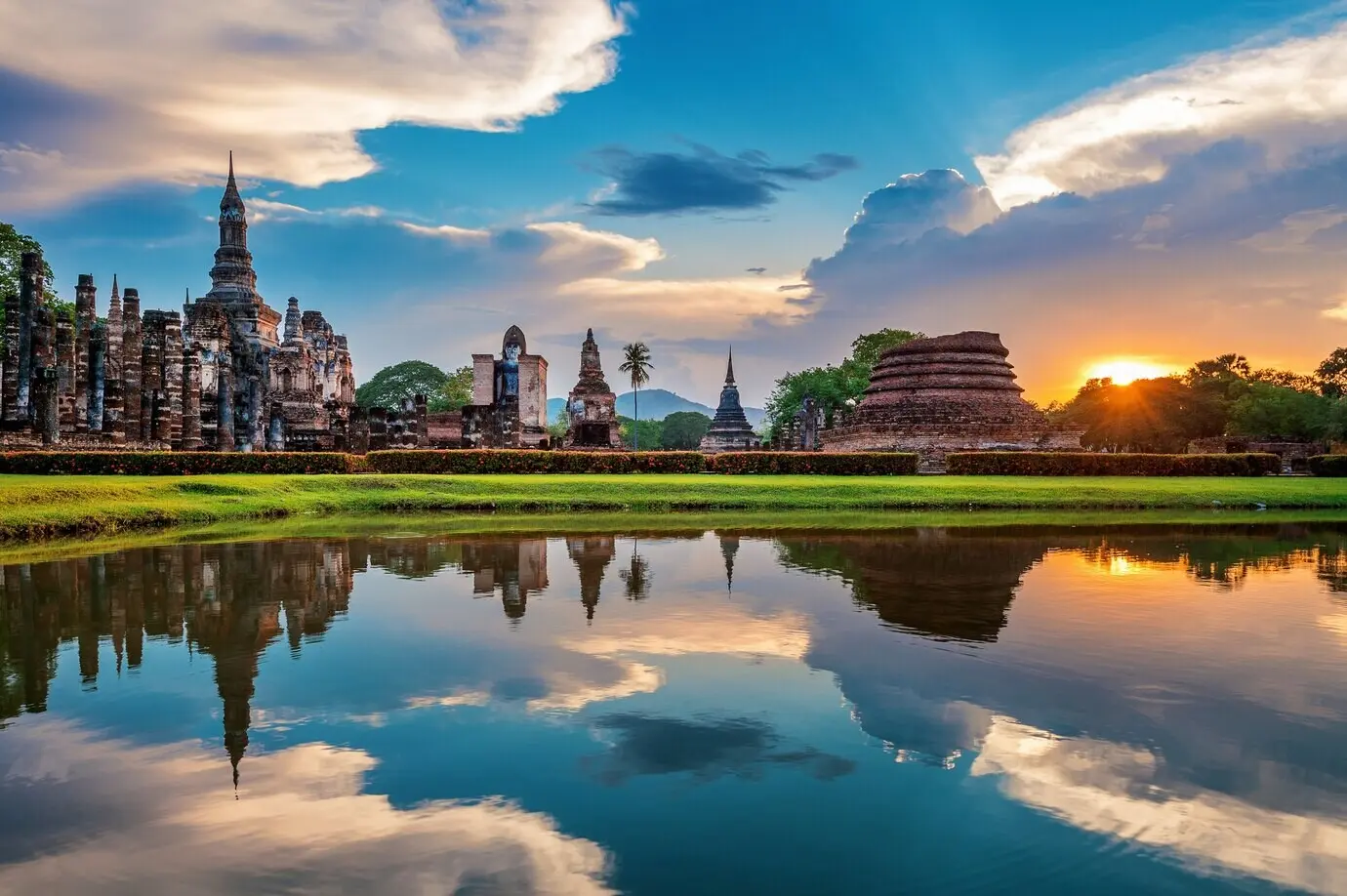Buddhastatue und Wat-Mahathat-Tempel auf dem Gelände des Sukhothai Historical Parks